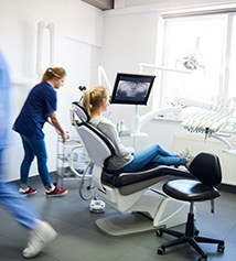 Blurred dentists helping a patient through her dental emergency