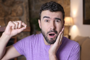 Man holding his knocked-out tooth and looking shocked